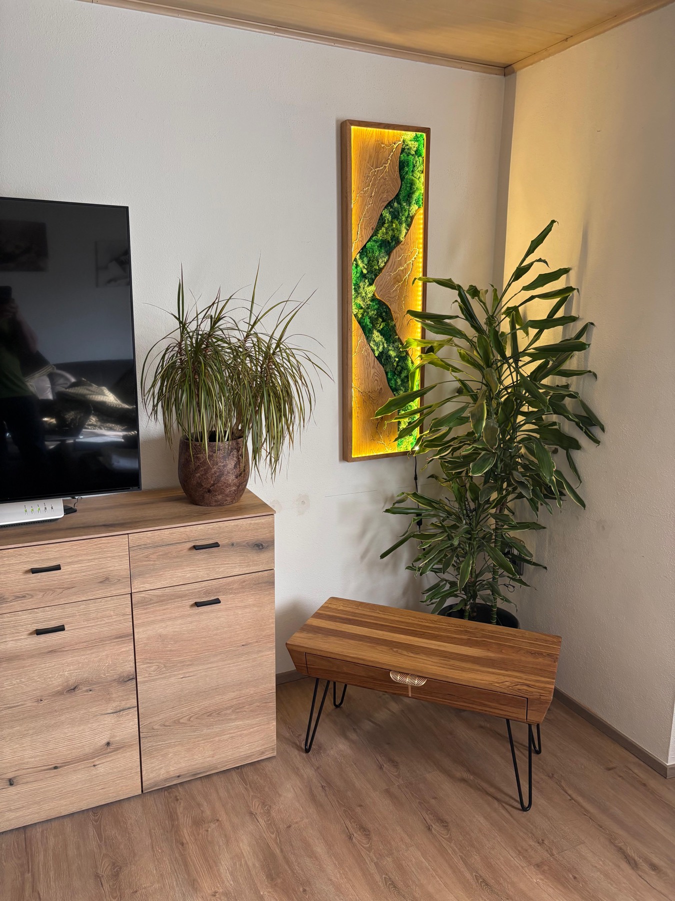 Modernes Wohnzimmer mit Mooswand und Couchtisch aus Eiche